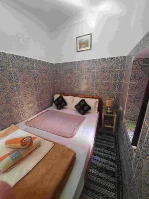 a small room with two beds in it at Riad 112 in Marrakech