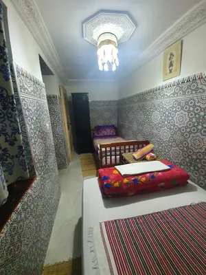 a bedroom with two beds and a chandelier at Riad 112 in Marrakech