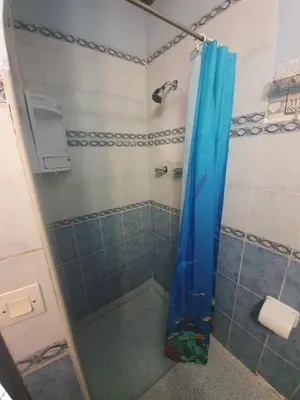 a shower with a blue shower curtain in a bathroom at Riad 112 in Marrakech