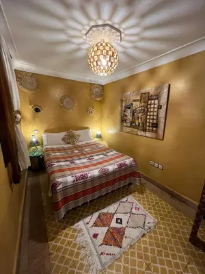 a bedroom with a bed and a chandelier at Riad Andalla in Marrakech