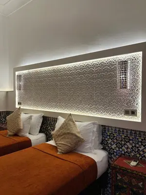 a hotel room with two beds and a mirror at Riad Andalla in Marrakech