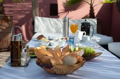 a table with a blue table cloth with a basket of bread at Dar Rocmarra in Marrakech