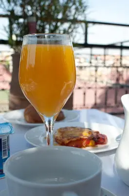 a glass of orange juice next to a plate of food at Dar Rocmarra in Marrakech
