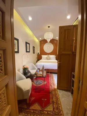 a hotel room with a bed and a red rug at Elegancia Riad Boutique & SPA in Marrakech