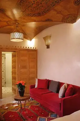 a living room with a red couch and a table at Elegancia Riad Boutique & SPA in Marrakech