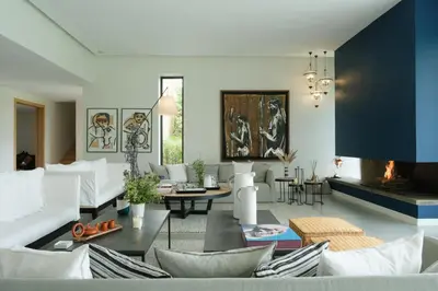 a living room with white furniture and a fireplace at Villa BELYA in Marrakech