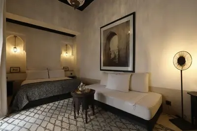 a hotel room with two beds and a table at Riad Azzouna 13 in Marrakech