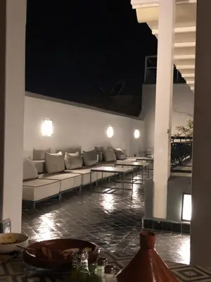 a living room with a couch and tables at night at Riad Dar Bahi in Marrakech