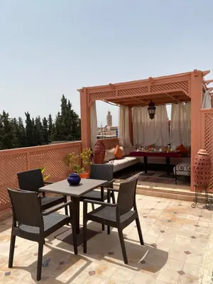 a patio with a table and chairs and a gazebo at Dar Asdika in Marrakech