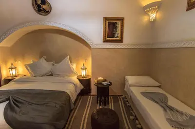 a bedroom with two beds and a bathtub next to at Riad Zen House in Marrakech