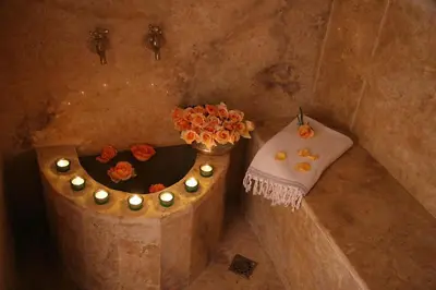 a bath tub with a vase of flowers and a towel at Riad Zen House in Marrakech