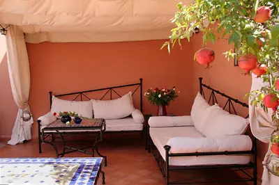 a room with two beds and a table with flowers at Riad Zen House in Marrakech