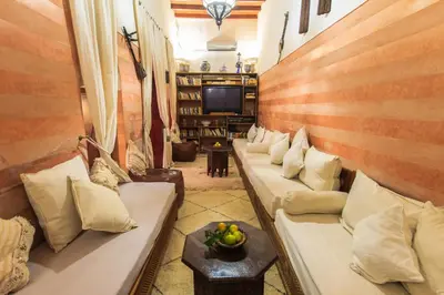 a living room with couches and a tv at Riad Zen House in Marrakech