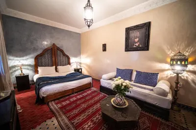 a bedroom with a bed and a couch in a room at Riad Mur Akush in Marrakech