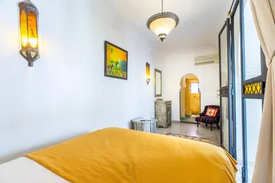 a bedroom with a yellow blanket on a bed at Riad El Youssoufi in Marrakech