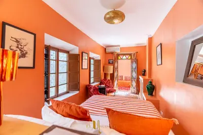 a bedroom with orange walls and a bed with orange pillows at Riad El Youssoufi in Marrakech