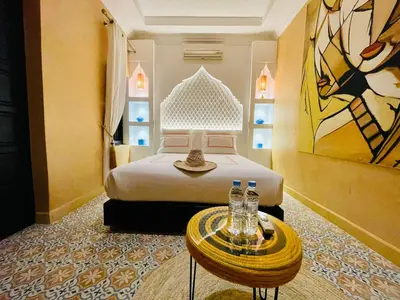a hotel room with a bed and a table with bottles on it at Maison Chafia Boutique Hôtel & Spa in Marrakech