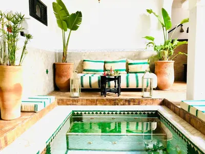 a pool in a house with a couch and a table at Maison Chafia Boutique Hôtel & Spa in Marrakech