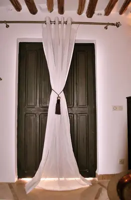 a white curtain in front of two black doors at Riad Essaada in Marrakech