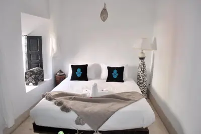 a bedroom with a bed with white sheets and pillows at Riad Essaada in Marrakech