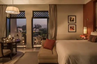 a bedroom with a bed and a couch and a table at Four Seasons Resort Marrakech in Marrakech