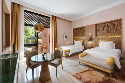 a hotel room with two beds and a table at Four Seasons Resort Marrakech in Marrakech