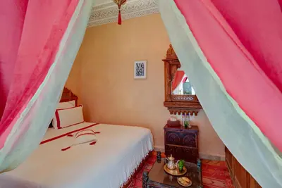 a bedroom with two beds and a mirror at Samira Group & Spa in Marrakech