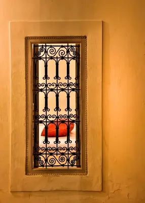 a window with a iron grate on a wall at Hotel & Spa Riad Al Jazira in Marrakech