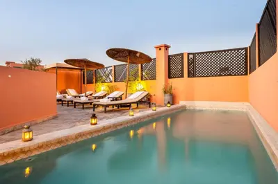 an infinity pool with lounge chairs and a resort at Riad 64 Maison D'hôtes & Spa in Marrakech