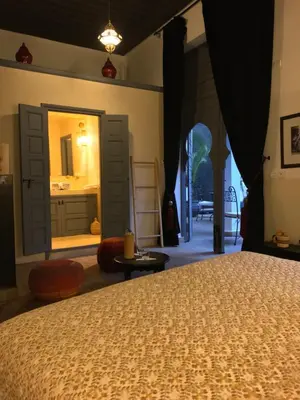 a bedroom with a bed and a bathroom with a sink at Riad 64 Maison D'hôtes & Spa in Marrakech