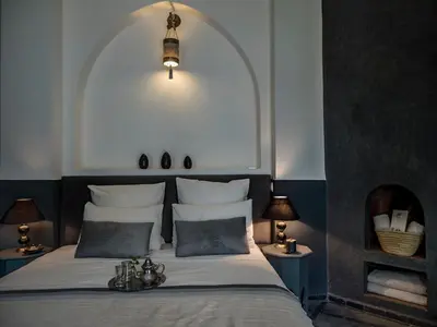 a bedroom with a bed and two tables with lamps at Riad 64 Maison D'hôtes & Spa in Marrakech