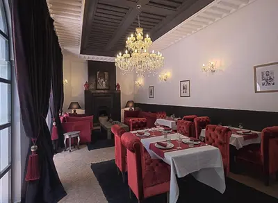 a restaurant with red chairs and tables and a chandelier at Riad 64 Maison D'hôtes & Spa in Marrakech