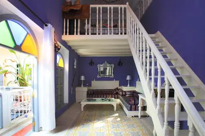 a living room with a staircase and purple walls at Riad Noos Noos & Spa in Marrakech