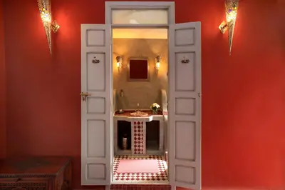 a bathroom with an open door with a sink at Riad Noos Noos & Spa in Marrakech