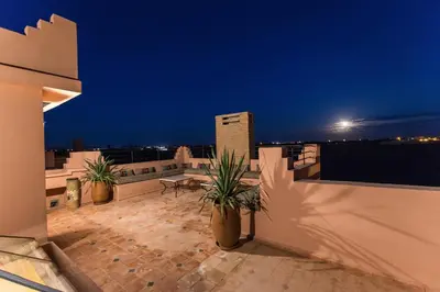 a balcony with potted plants on the roof at night at VILLA ILYANA in Marrakech