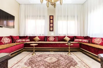 a living room with a red couch and a rug at VILLA ILYANA in Marrakech