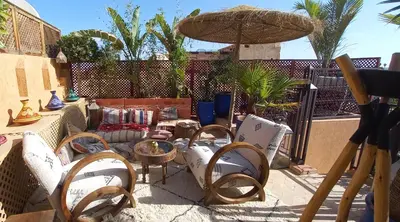 a group of chairs and tables on a patio at Riad Melhoun & Spa in Marrakech