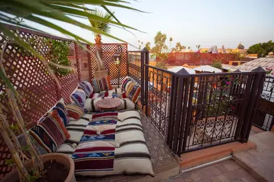 a balcony with a bench with pillows on it at Riad Melhoun & Spa in Marrakech