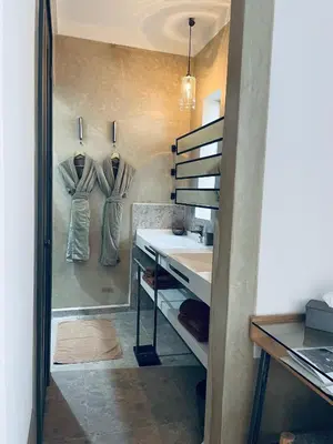 a bathroom with a sink and two robe hooks at Riad Dar 73 in Marrakech
