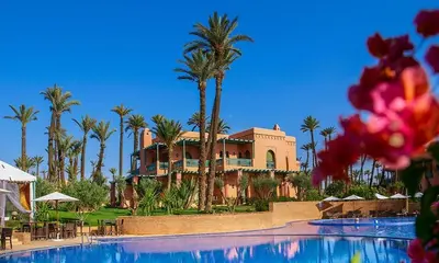 a resort with a large swimming pool and palm trees at la palmeraie village Appartement in Marrakech