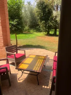 a patio with a table and chairs on a patio at la palmeraie village Appartement in Marrakech