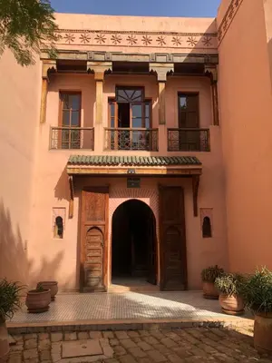 an entrance to a building with an arch and a balcony at la palmeraie village Appartement in Marrakech