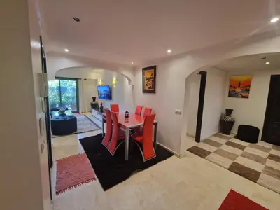 a dining room with a table and red chairs at Elegant Gueliz Retreat near Majorelle in Marrakech