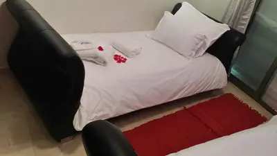 a small bed with white sheets and pillows on it at Elegant Gueliz Retreat near Majorelle in Marrakech