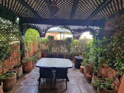 a patio with a table and a lot of potted plants at Elegant Gueliz Retreat near Majorelle in Marrakech