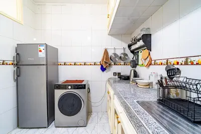 a kitchen with a refrigerator and a washing machine at Appart Atlas in Marrakech