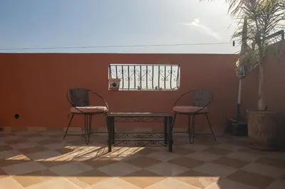 two chairs and a table in a room with a window at Appart Atlas in Marrakech
