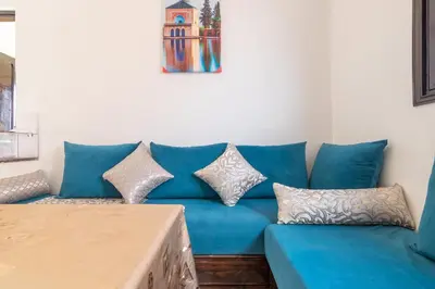 a blue couch with pillows in a living room at Appart Atlas in Marrakech