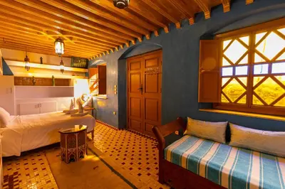 a bedroom with a bed and a couch in a room at Riad Aicha Marrakech in Marrakech