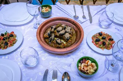 a table with a bowl of food and plates of food at Riad Aicha Marrakech in Marrakech